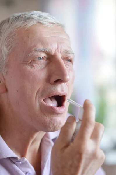 Older man taking a medicine — Stock Photo, Image