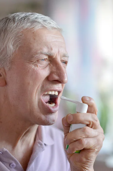 Older man taking a medicine — Stock Photo, Image