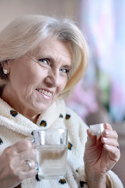 Older woman taking a medicine — Stock Photo, Image