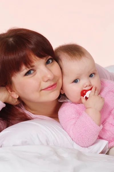 En kaukasisk mamma med sin dotter i sängen — Stockfoto