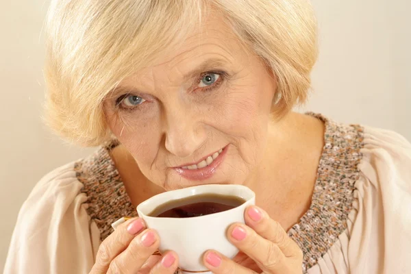 Happy old woman with coffee — Zdjęcie stockowe