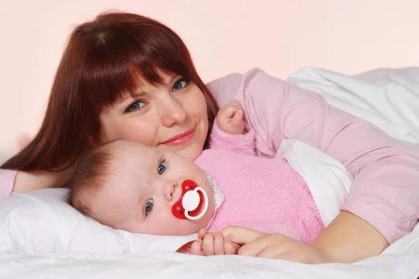 Eine schöne Mumie mit ihrer Tochter im Bett liegend — Stockfoto