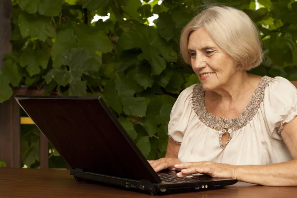 Härliga äldre kvinna sitter på verandan — Stockfoto