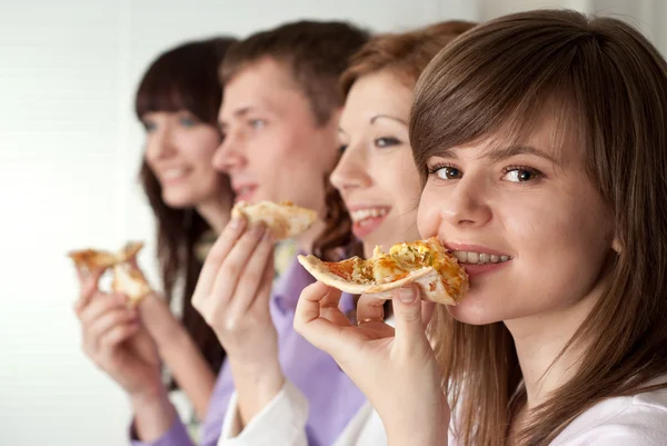 Menino e meninas comem a pizza — Fotografia de Stock