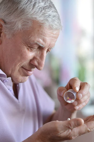 Older man taking a medicine — Stock Photo, Image