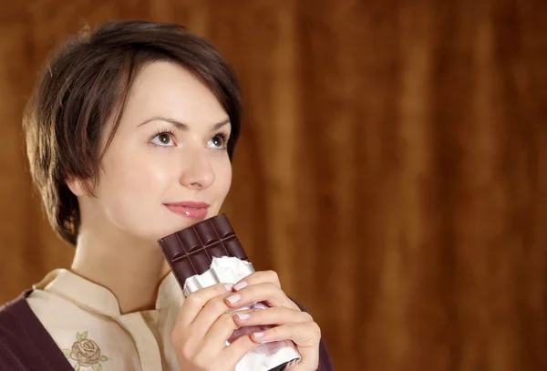 Vrouw met een chocolade bar in zijn handen — Stockfoto