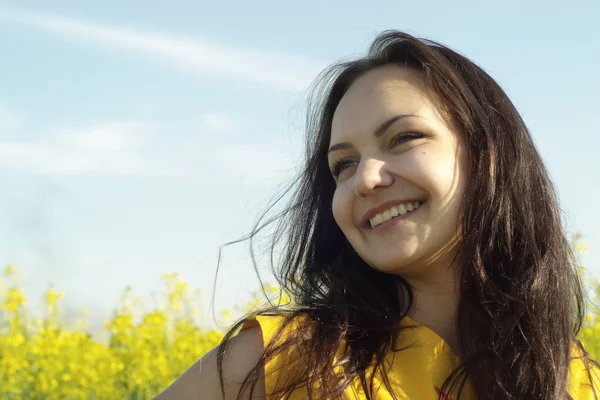 Mulher jovem bonita no meio de flores amarelas — Fotografia de Stock