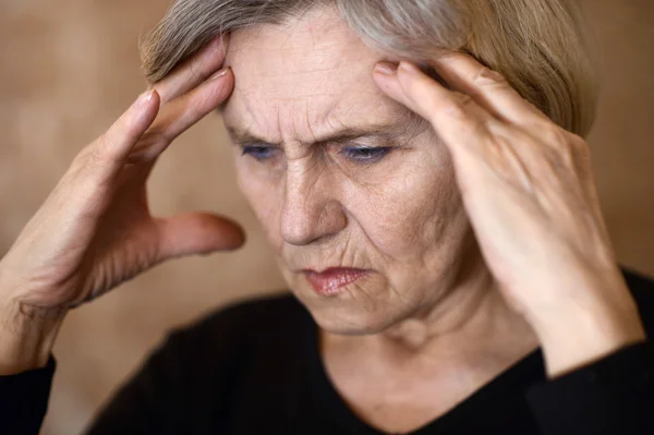 Ältere Frau mit Kopfschmerzen — Stockfoto