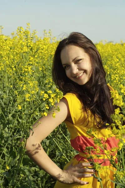 Hezká mladá žena uprostřed žluté květy — Stock fotografie