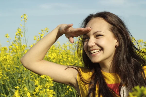 Mulher jovem soberba no meio de flores amarelas — Fotografia de Stock