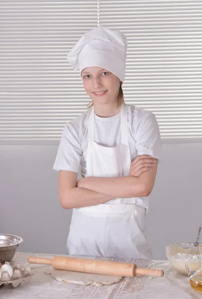 Niño en un sombrero de chef amasar masa para galletas —  Fotos de Stock