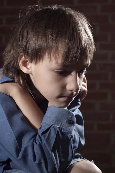 Caucasian child frustrated sitting in a deserted place — Stock Photo, Image