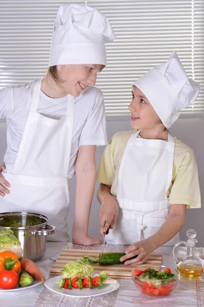 Dva mladí kluci připravují večeře v kuchyni — Stock fotografie