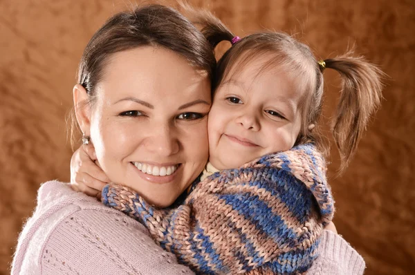 Portret van een mooie moeder en dochter op een brown — Stockfoto