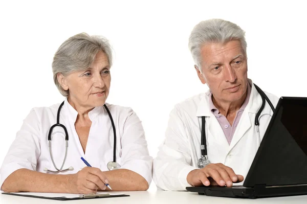 Starší lékaři s notebookem na bílé — Stock fotografie