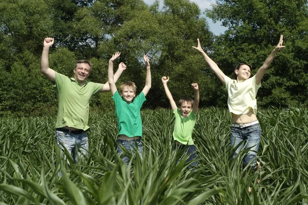 Família feliz de quatro passa o tempo ao ar livre no verão — Fotografia de Stock
