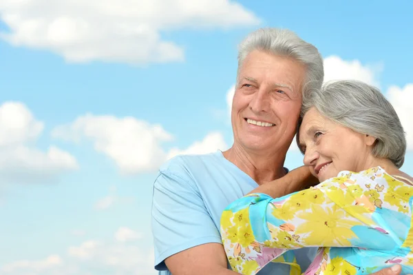 Gelukkig bejaarde echtpaar op een hemelachtergrond — Stockfoto