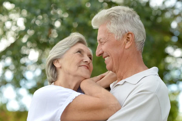 Loving aged couple on a background of trees — Stock Photo, Image