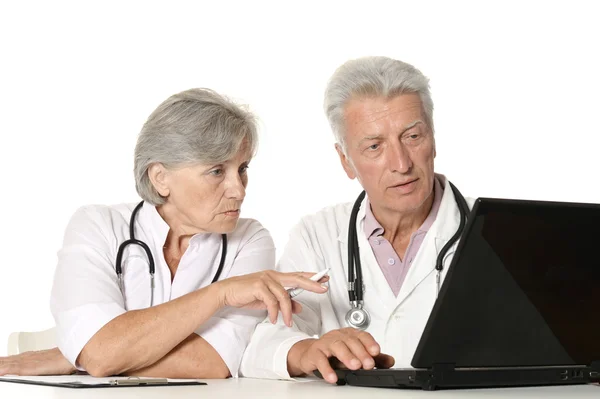 Medici anziani con un computer portatile su un bianco — Foto Stock