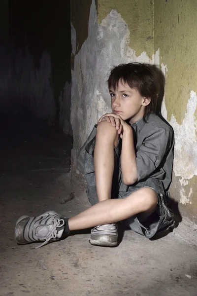Enfant caucasien frustré assis dans un endroit désert — Photo