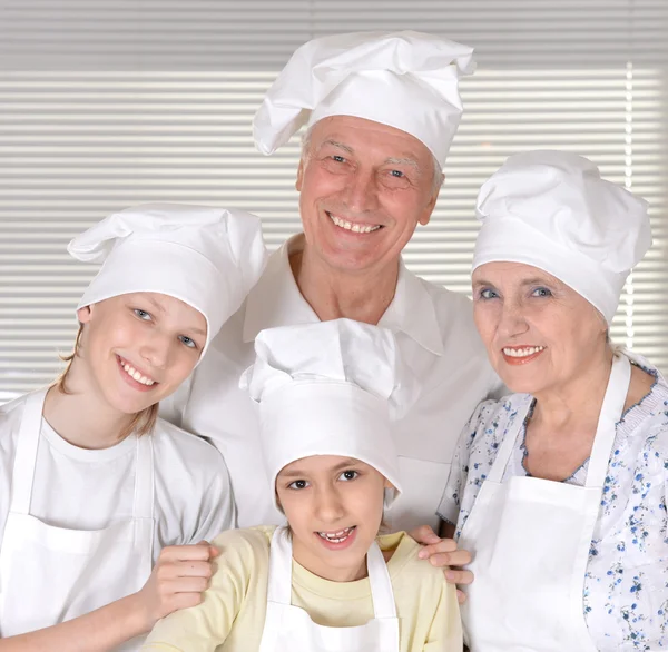 Older couple and their grandchildren knead the dough for biscuits together — Stock Photo, Image
