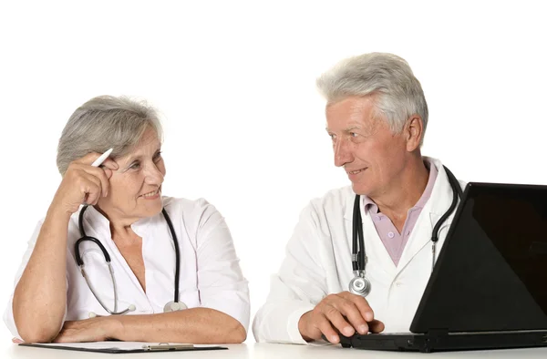 Ältere Ärzte mit Laptop auf weißem Hintergrund — Stockfoto