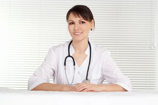 Krankenschwester mit Stethoskop auf braunem Hintergrund — Stockfoto