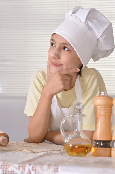 Young boy in a chef's hat knead dough for cookies — Stock Photo, Image