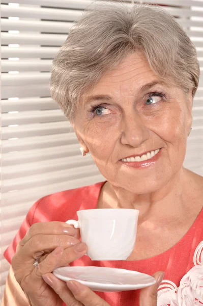 Retrato de uma mulher de meia-idade atraente em um vestido vermelho — Fotografia de Stock