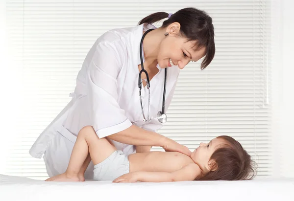 Médico pediatra con niña en su consultorio —  Fotos de Stock