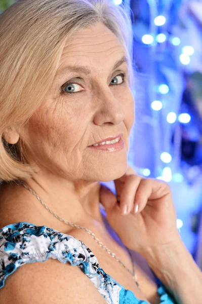 Veselý starší žena na modrém pozadí — Stock fotografie