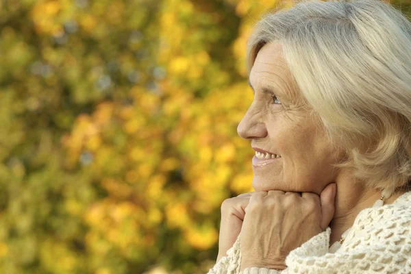 Senior woman in the park in autumn — Stock Photo, Image