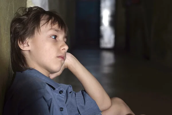 Caucasian child frustrated sitting in a deserted place — Stock Photo, Image