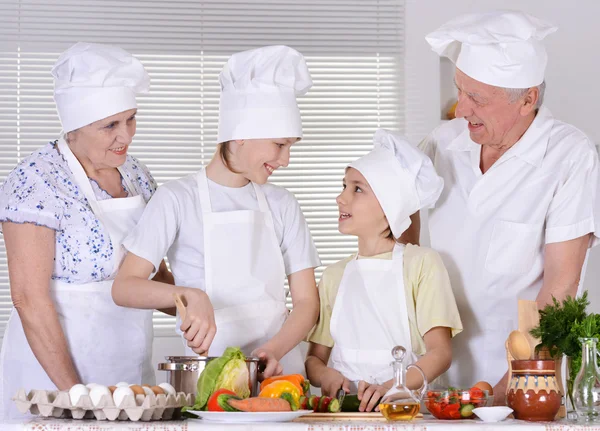 Avós felizes e seus netos cozinham juntos — Fotografia de Stock