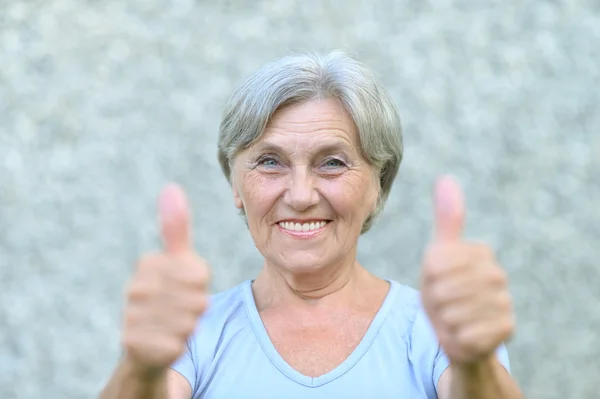 Gut aussehende alte Frau auf blauem Hintergrund — Stockfoto