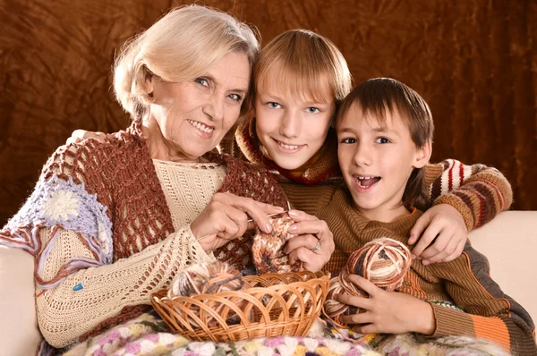 年配の女性は彼女の孫と肘掛け椅子に腰掛けて編み物 — ストック写真