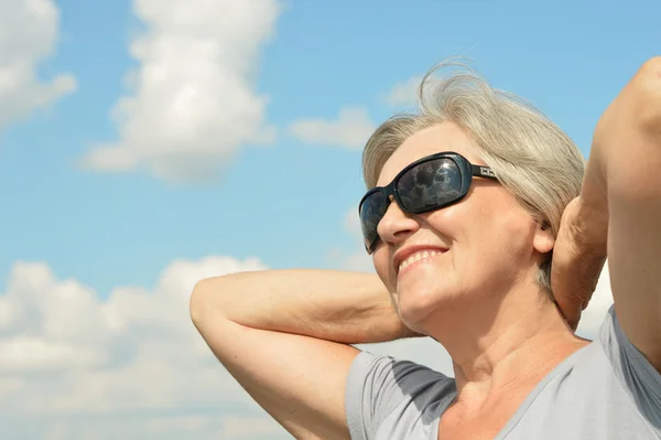 Portrét krásné zralé ženy na pozadí oblohy — Stock fotografie