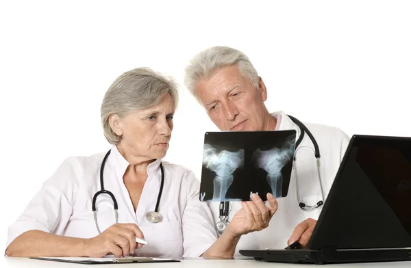 Médicos idosos com um laptop olhando para raio-x em um branco — Fotografia de Stock
