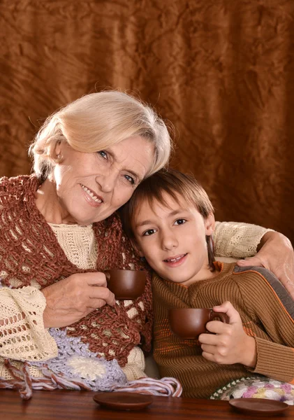 Senior woman dring coffee with her grandson — Stock Photo, Image