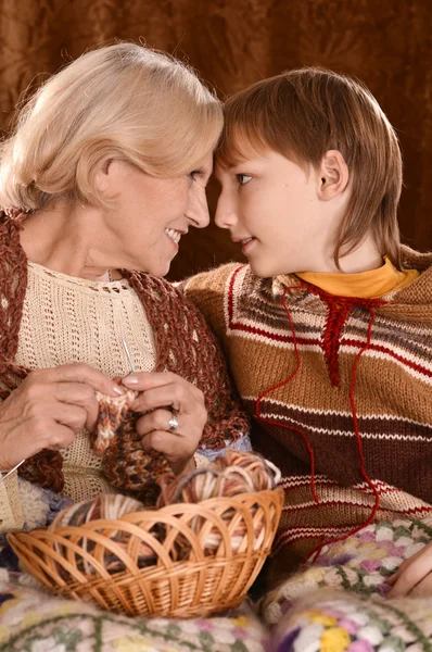 Senior vrouw breien in fauteuil met haar kleinzoon — Stockfoto