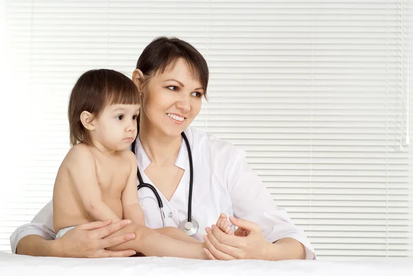 Médico pediatra con niña en su consultorio —  Fotos de Stock