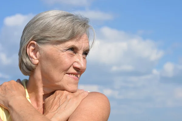 Szczęśliwy starsza kobieta pozowanie przed niebo — Zdjęcie stockowe
