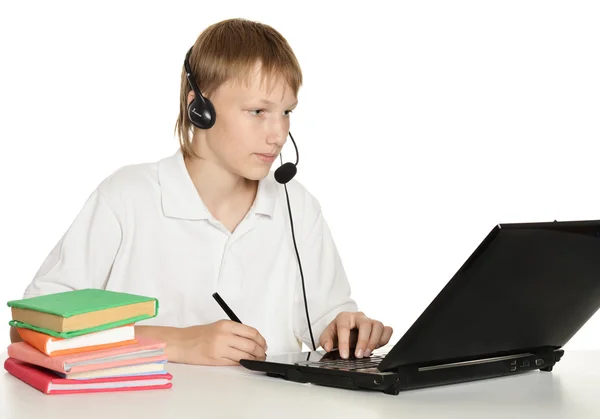 Мальчик-подросток делает уроки с ноутбуком — стоковое фото