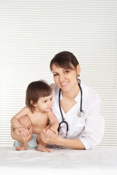 Pediatrician doctor with little girl in her office Stock Photo
