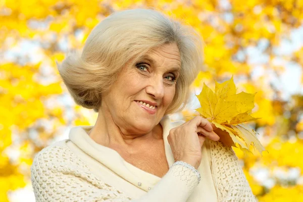 Old woman on a yellow — Stock Photo, Image