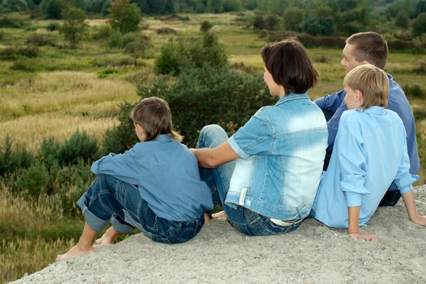 Šťastní rodiče a děti sedět — Stock fotografie