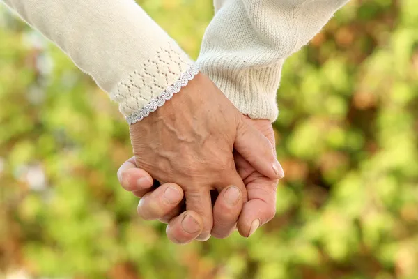 Elderly couple holding hands — Stock Photo, Image