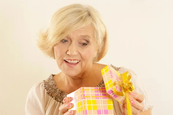 Portrait of happy beautiful old woman with a gift — Stock Photo, Image