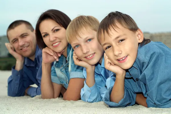 Leuke familie van vier liegen — Stockfoto