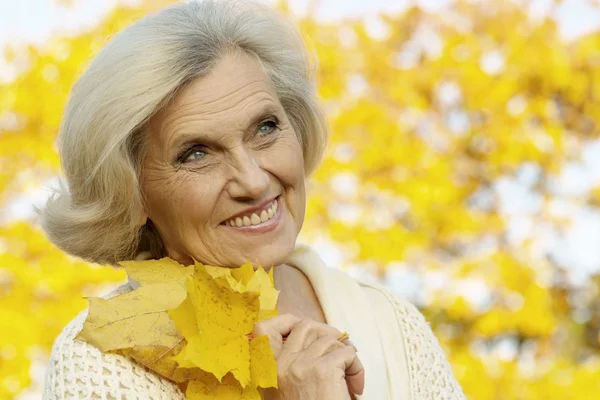 Old woman on a yellow background — Stock Photo, Image